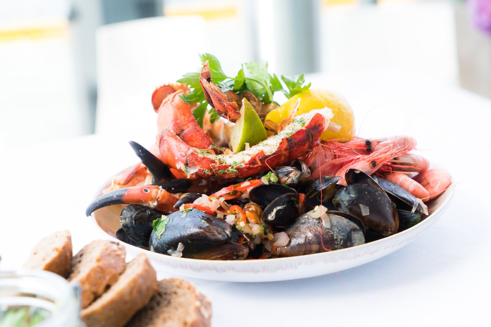 A piled seafood plate of lobster, shrimp, and mussels