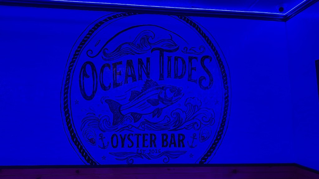 The Ocean Tides Oyster Bar logo painted on the wall