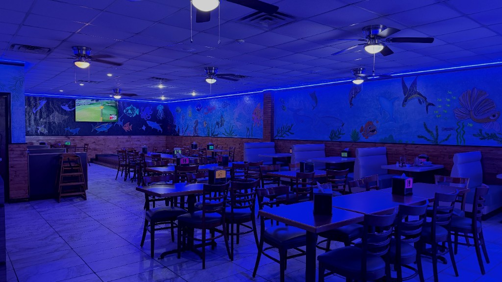 The dining room, with tables, booths, and the sea-life mural